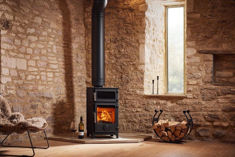 Contemporary wood-burning stove with glass door and sleek black finish in Southwest England living room