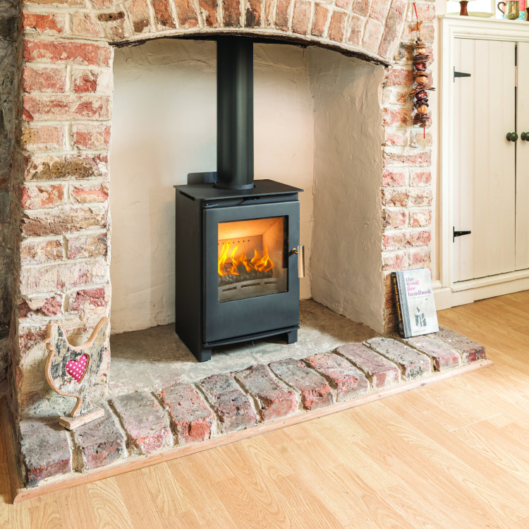 Modern Heta wood-burning stove installed in a Cornwall home with stone surround and hearth