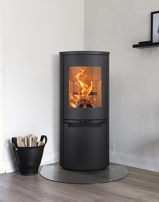 Freestanding Heta wood-burning stove glowing in traditional Cornwall home