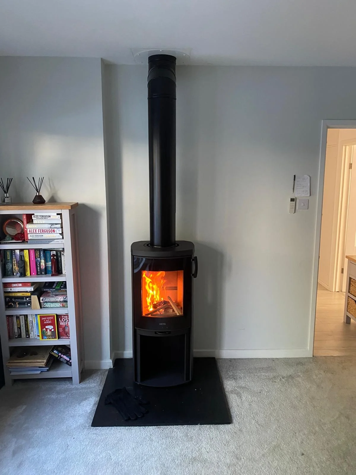 Heta wood burning stove black freestanding with twin wall flue pipe installed in modern living room
