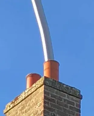 Chimney re-lining installation Cornwall — stainless steel liner in brick chimney breast