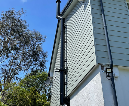 External twin wall flue system installation Cornwall — stainless steel flue pipe on exterior wall